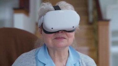 VR Google 'daki mutlu son sınıf öğrencisinin yakın plan portresi evde salonda şarkı söyleyip gülümsüyor. Mutlu Kafkasyalı emekliler artırılmış gerçeklikte karaokenin tadını çıkarıyor. Modern teknolojiler kolaylık