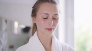 Yavaş çekimde kameraya bakarak ferahlatıcı organik detoks limon suyu içen kendine güvenen güzel bir kadının portresi. Göz bantlı, güzelliğiyle ilgilenen bin yıllık beyaz bir kadın..
