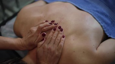 Beyaz kadın avuçlarında uzun, kaygan avuçlar, belinde yağ parlatıcısı ve havlu, manikürlü tırnakları olan terapist, rahatlatıcı.