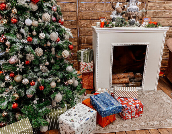 Decorated Christmas tree. Close-up. Fireplace by the Christmas tree with gifts