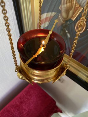 Yağ ikonu lambasında yanan ateş. Kilisede kolye lambası. Dini gereçler. Eski tarz yaldızlı tutucu. Şeffaf camdan yapılmış simge lambası. 