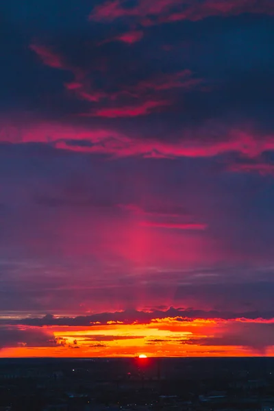 Colorful sunset sky, purple clouds and red sun