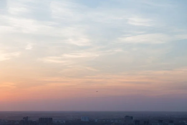 Das Flugzeug fliegt in Pastellfarben durch den wunderschönen Sonnenuntergangshimmel — Stockfoto
