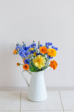 Wild flowers from the field in the white rural jug on the table, summer interior decor clipart