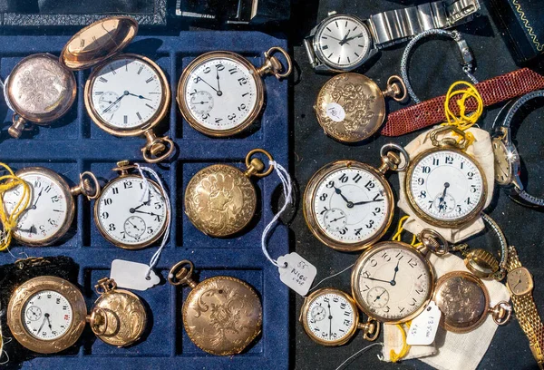 A beautiful display of antique pocket watches are for sale at an outdoor event