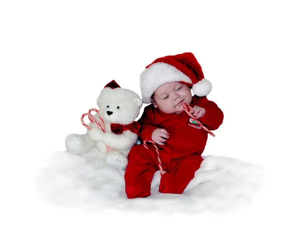 Малыш в костюме Санты с игрушками и конфетами — стоковое фото