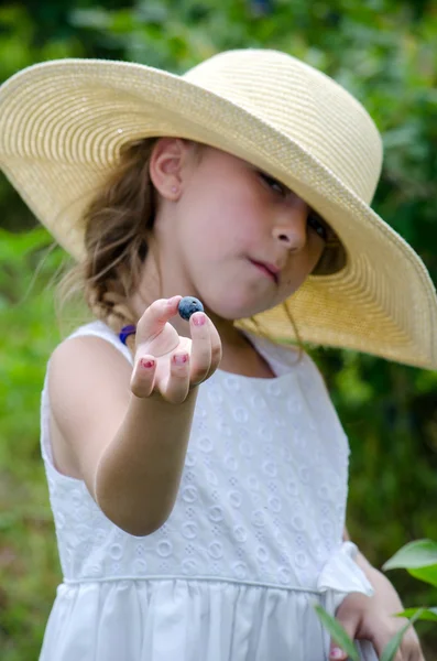 Menina oferecendo um mirtilo — Fotografia de Stock