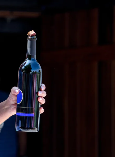 Hand holding bottle of wine — Stock Photo, Image