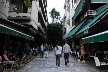 Koruyucu yüz maskesi takan insanlar, 30 Ekim 2020 'de Atina şehir merkezinde, Yunanistan' da yürürler..