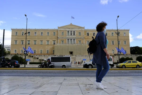 Koruyucu yüz maskesi takan insanlar, 30 Ekim 2020 'de Atina şehir merkezinde, Yunanistan' da yürürler..
