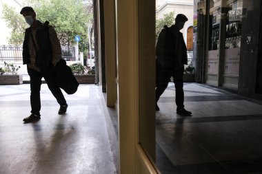 Koruyucu yüz maskesi takan insanlar, 3 Kasım 2020 'de Atina şehir merkezinde yürürler..