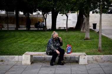 Korunaklı yüz maskeleri takan insanlar, 3 Kasım 2020 'de Atina, Yunanistan' da, koronavirüs hastalığı (COVID-19) salgını sırasında ticari bir sokakta yürüyorlar.