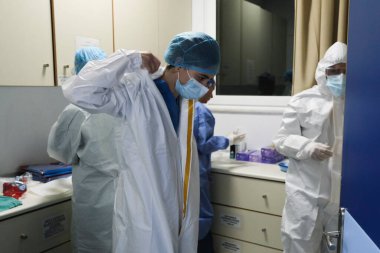 Yunanistan 'da 5 Kasım 2020' de Atina Hastanesi 'nde COVID-19 hastalarına yardım etmeden önce bir sağlık çalışanı kişisel koruyucu ekipman (PPE) giyiyor.