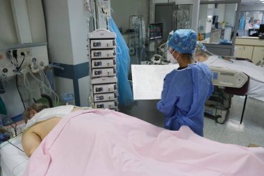Yunanistan 'da 5 Kasım 2020' de Atina Hastanesi 'nde Coronavirus hastalığı (COVID-19) geçiren hastalar için yoğun bakım ünitesinde koruyucu giysi ve maskeli doktorlar.