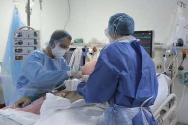 Yunanistan 'da 6 Kasım 2020' de Atina Hastanesi 'nde Coronavirus hastalığı (COVID-19) geçiren hastalar için yoğun bakım ünitesinde koruyucu giysi ve maskeli doktorlar.