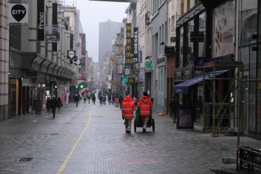 30 Kasım 2020 'de Brüksel, Belçika' da Coronavirus, COVID-19 'un yayılmasını önlemek için bir gün önce, ticari caddede yüz maskesi takmış insanlar yürüyorlar..