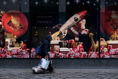 30 Kasım 2020 'de Brüksel, Belçika' da Noel için dekore edilmiş vitrinlere bakan yüz maskesi takan insanlar.