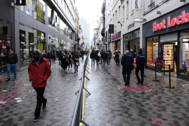 Yüz maskesi takan insanlar 1 Aralık 2020 'de Brüksel, Belçika' da yeniden açılan bir dükkanın önünden geçiyorlar..