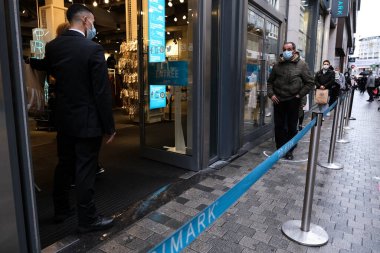 1 Aralık 2020 'de Brüksel' de, Neuve sokağındaki bir dükkanın önünde kuyruğa giren insanlar, yeni Coronavirus salgınının ortasında temel olmayan ürünler satan dükkanların yeniden açılmasına izin veriliyor.. 
