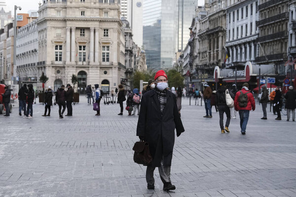 An elderly man wearing a face mask,  walks  in downtown Brussels, Belgium, Dec. 1, 2020.