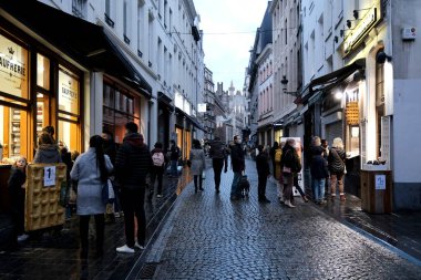 İnsanlar 23 Aralık 2020 'de Brüksel, Belçika' daki pastaneden waffle almak için bekliyorlar.