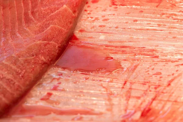 血の跡のある新鮮なマグロの魚のスライス 伝統的な魚市場の健康的な海の食べ物で 肉屋の縞模様があります 寿司ランチやグルメディナーのための質の高い料理 — ストック写真