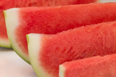 Sulu tropikal karpuz, tatil içeceklerini sıraya dizer. Kahvaltıda, tatlıda veya atıştırmalıkta sağlıklı beslenme için marketten dilimlenmiş karpuz meyvesi parçaları. Tatlı, taze yaz tatili yemeği.