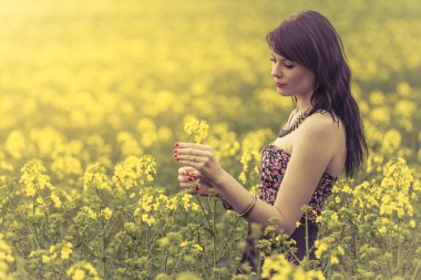 Çayır sarı çiçek çiçek tutan güzel kadın