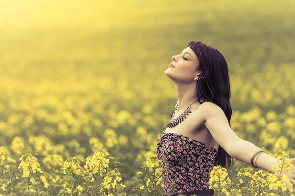 Happy woman in ocean of yellow flowers — Stock Photo, Image