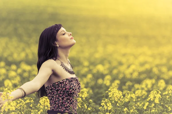 Heureuse femme positive dans l'océan ensoleillé d'été de fleurs jaunes — Photo