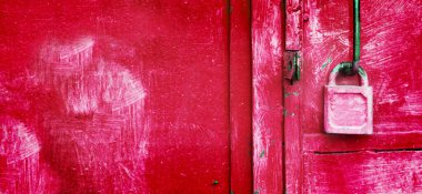 Paslı garaj kapısında asılı canlı pembe asma kilit. Veri kilidini aç, güvenli bilgi kavramı. Aşk ve ilişki kavramı