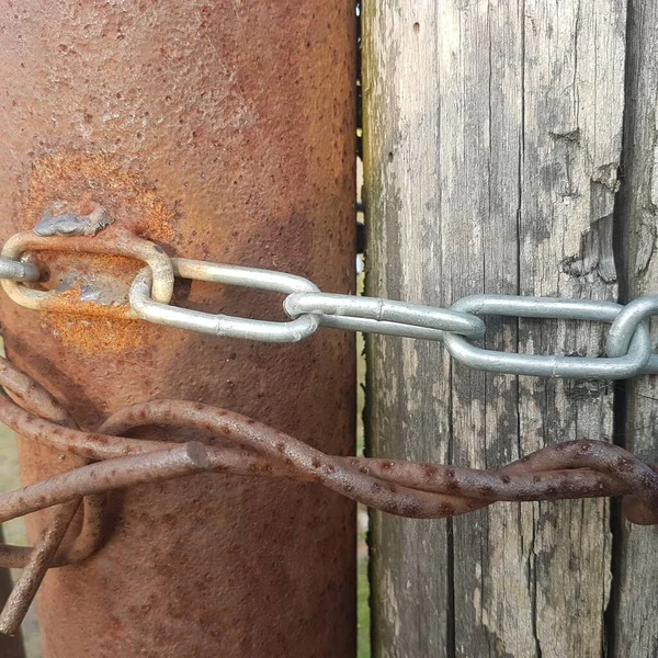 Zardzewiałe słupy molo z metalowym łańcuchem i zardzewiałym drutem. Połączenie i powiązanie koncepcji biznesowej — Zdjęcie stockowe
