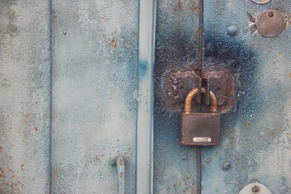 Old Lock hangs on a garage door with copyspace on the right. Locked content informational concept. Safe data concept.