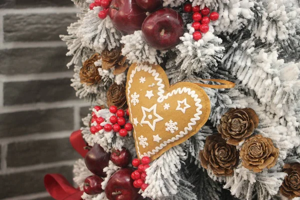 Christmas decoration with gingerbread heart, red berries hanging on white fir. Christmas background — Stock Photo, Image