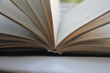 Karanlık ve soyut bir arka planda doğrudan ışık alan eski açık bir kitap. Eğitim ve bilgelik kavramı.