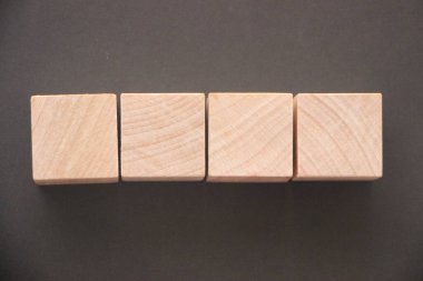 Siyah arkaplanda dört tahta blok var. Eğitim kavramı.