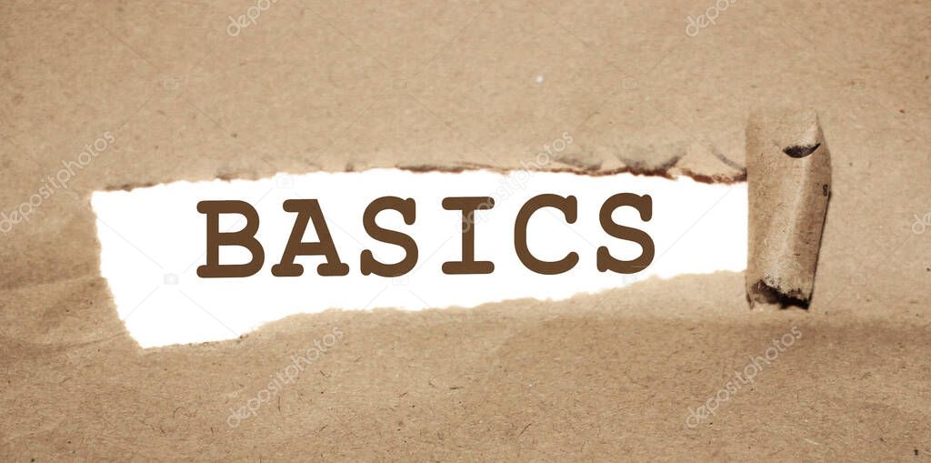 The word Basics appearing behind torn brown paper. Education concept.