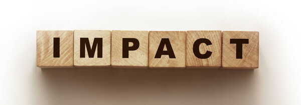 Impact word from wooden cubes. Office desk, informative and communication business concept