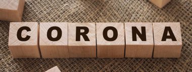 Tahta blokta Coronavirus kelimesi yazıyor. Ahşap masadaki koronavirüs metni nedir? Coronavirus konsepti üst görünüm için..