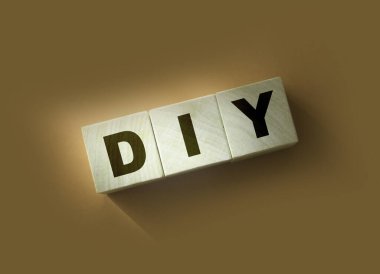 Ahşap küp bloklar ve kırmızı arka planda DIY harfleri. Kopyalama alanı ile iş kavramı