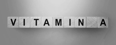 VITAMIN tıbbi bir kavram. Gök mavisi masasında harfleri olan tahta küpler..