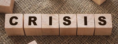 Çuval bezi arka planında tahta küp bloklarda kelime krizi. İş sonbahar konsepti.