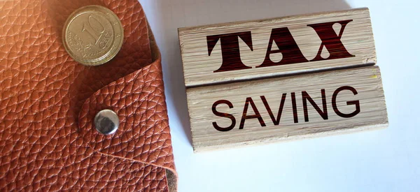 TAX saving words on wooden blocks, wallet, coins. Business concept The concept of taxation, increase taxes and fees.