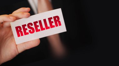 Reseller kelimesinin yazılı olduğu bir kart tutan bir iş adamı. İş konsepti yeniden yükleniyor.