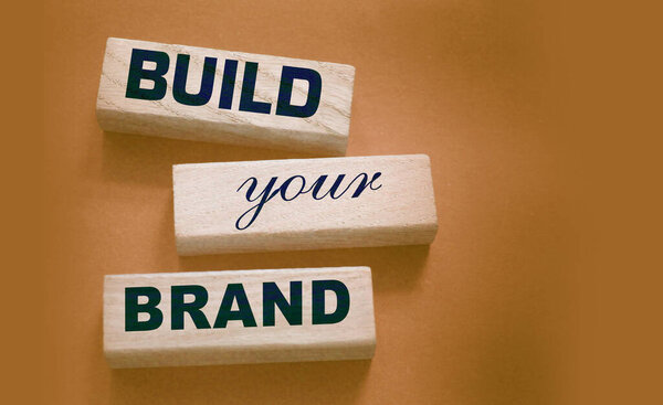 Фраза BUILD YOUR BRAND написана на деревянных блоках. С винтажным стилем. Рекламная концепция ребрендинга.