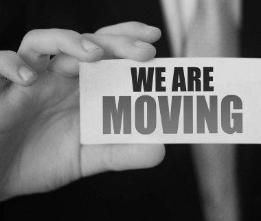 Taşıdığımız mesajın yazılı olduğu bir kart gösteren bir iş adamı. Konum adresi iş konsepti değiştiriliyor