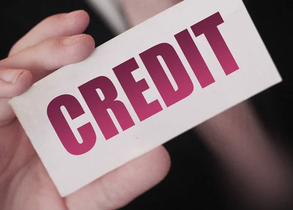 Crédito num cartão. Empresário segurando um cartão com a palavra Crédito. Conceito de negócio — Fotografia de Stock