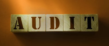 Kırmızı arkaplanda tahta bloklara yazılmış AUDIT kelimesi. Finansal iş muhasebe kavramı.