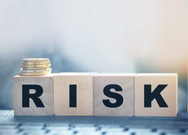 Risk Kelimesi Tahta Bloklar Bilgisayar klavyesinin ve bozuk para yığınının arkasına yerleştirildi. Riskli yatırım iş konsepti.