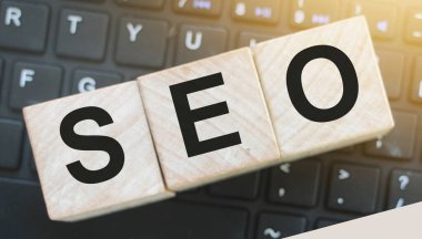Arama motoru optimizasyonu için kısaltması SEO olan tahta küpleri bilgisayar klavyesine yerleştirildi. Çevrimiçi iş projeleri metin yazma kavramı.